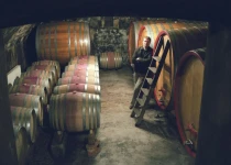 Paul Achs amidst barrels.
